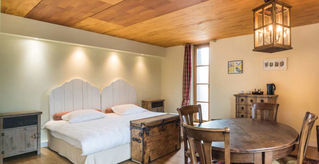 Double bed and wooden dinner table in a hotel room