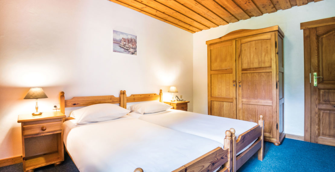 Twin beds and a closet in a hotel room